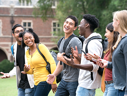 A group of students chatting happily while walking in the campus