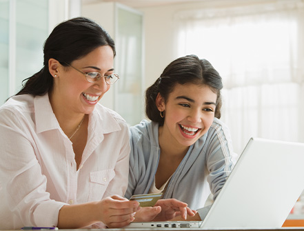 Mom and teen daughter using laptop