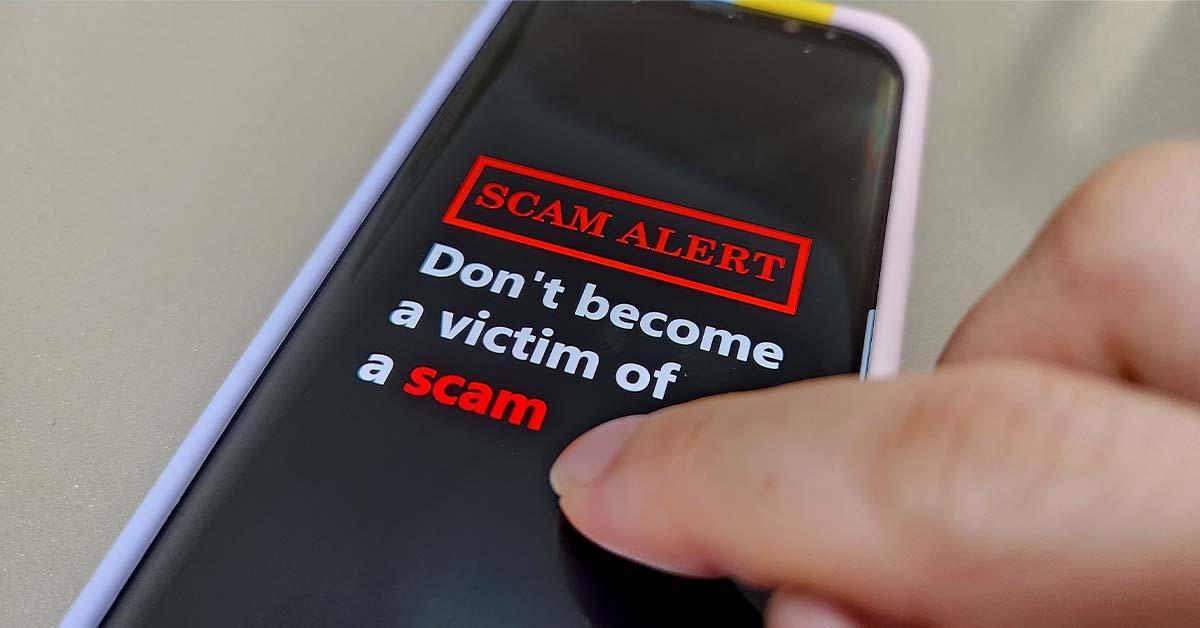 A person gets a bank notice warning against scams by text and email on their mobile device.